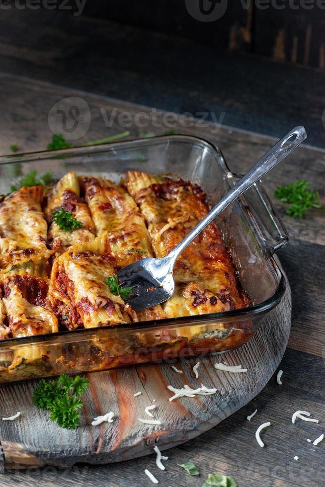 baked cannelloni pasta with spinach, ricotta in glass pan photo