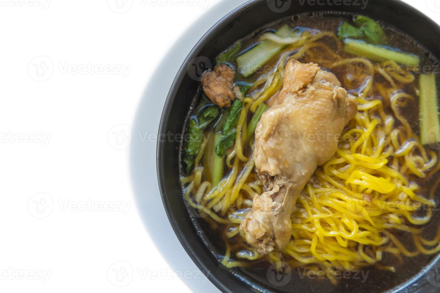 Yellow egg noodles stewed chicken wing in a black bowl isolated