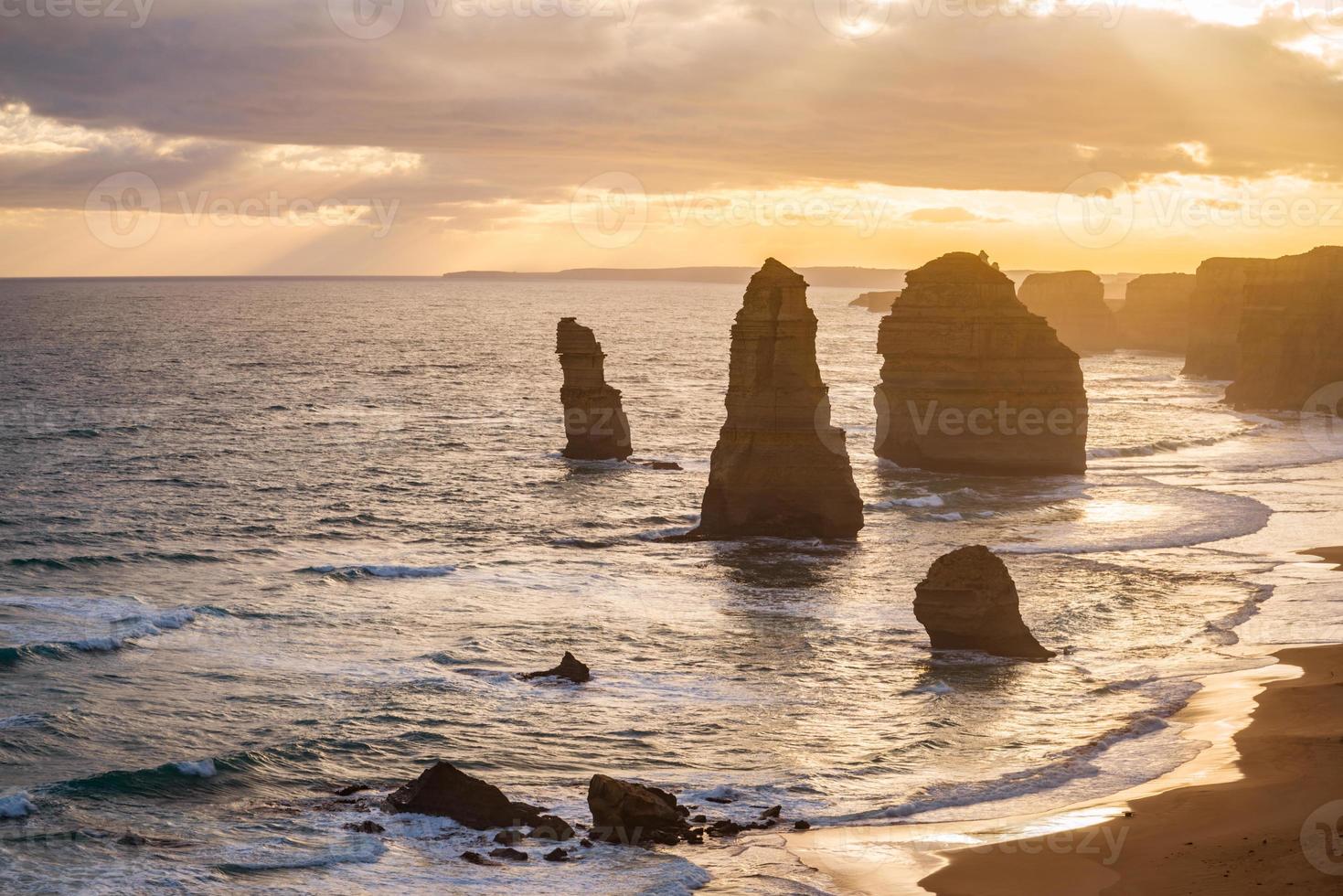 los doce apóstoles mecen el icónico hito natural de la gran carretera oceánica de australia durante la puesta de sol. foto