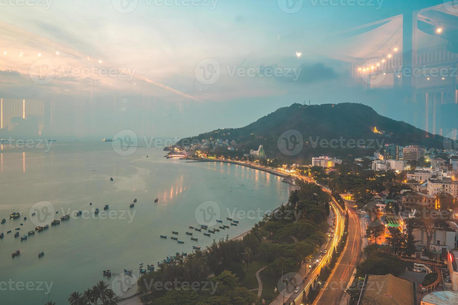 Vung Tau city aerial view with beautiful sunset and so many boats. Panoramic coastal Vung Tau view from above, with waves, coastline, streets, coconut trees and Tao Phung mountain in Vietnam. photo