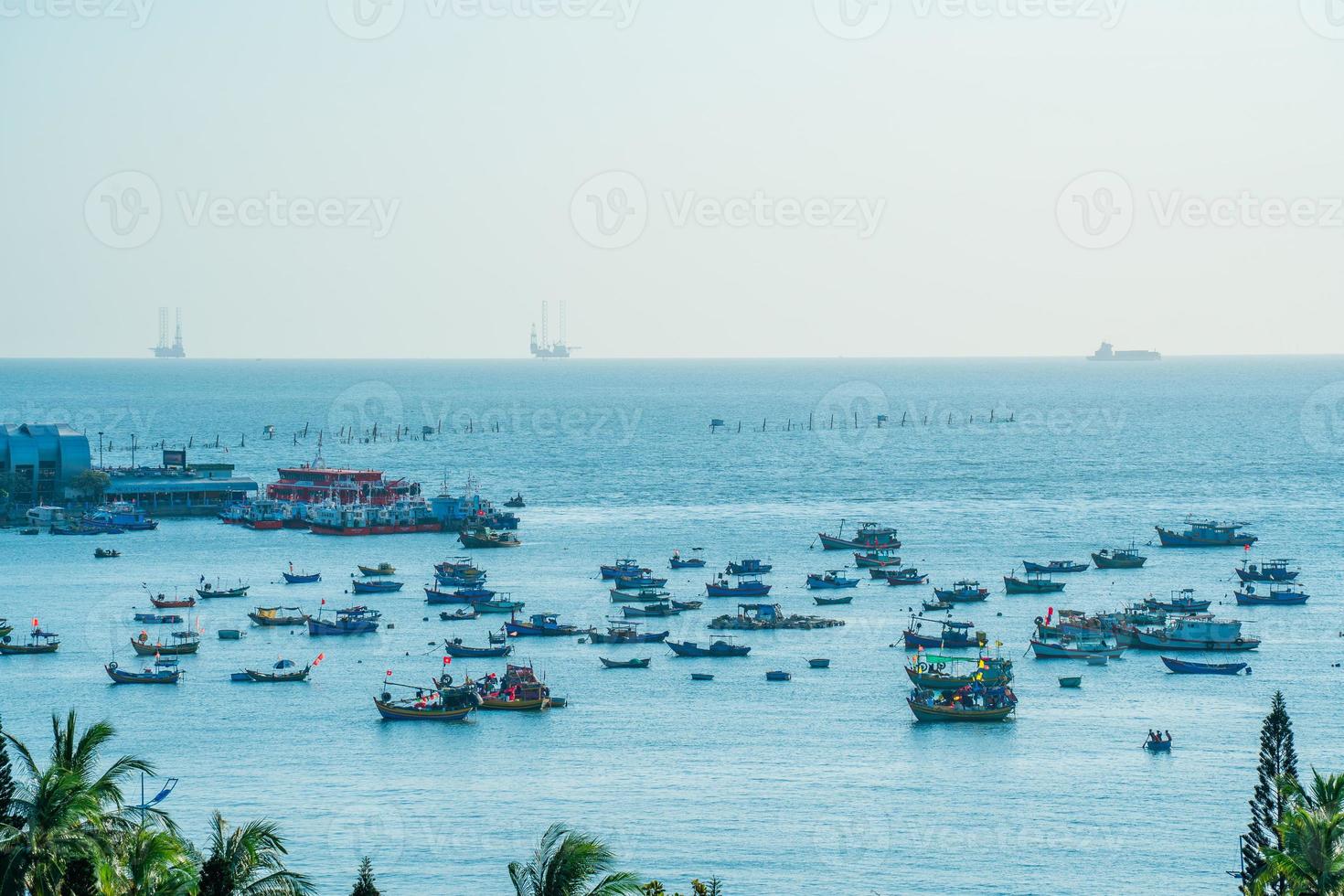 Vung Tau city aerial view with beautiful sunset and so many boats. Panoramic coastal Vung Tau view from above, with waves, coastline, streets, coconut trees and Tao Phung mountain in Vietnam. photo