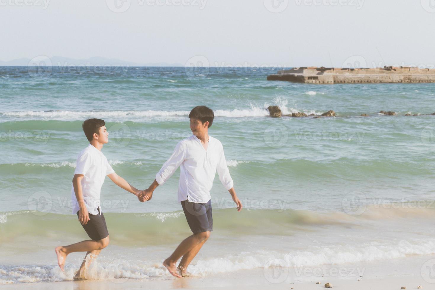 retrato homosexual joven pareja asiática corriendo alegremente juntos en la playa en verano, turismo gay de asia para el ocio y relajarse con felicidad en vacaciones en el mar, concepto legal lgbt. foto