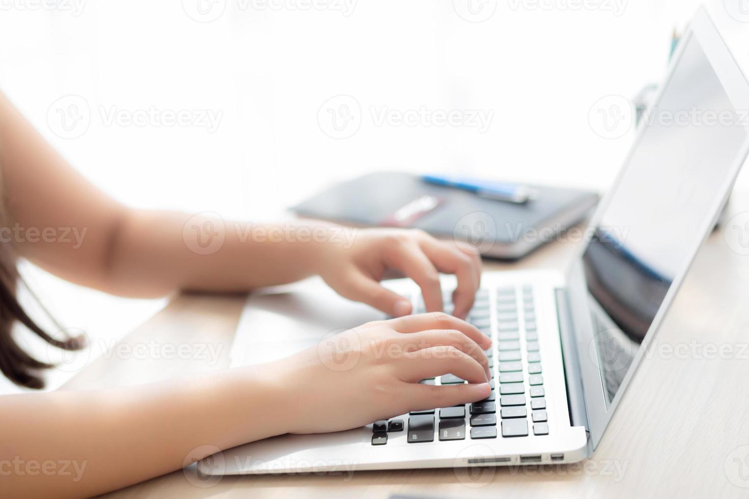 Closeup freelance asian woman working and typing on laptop computer at desk office with professional, girl using notebook checking email or social network, business and lifestyle concept. photo