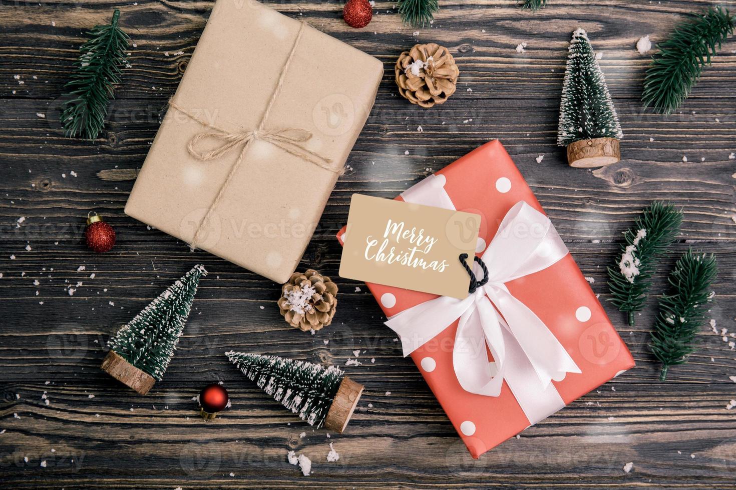 Christmas holiday composition with red gift box and tag decoration on wooden background, new year and xmas or anniversary with presents on wood table in season, top view or flat lay. photo