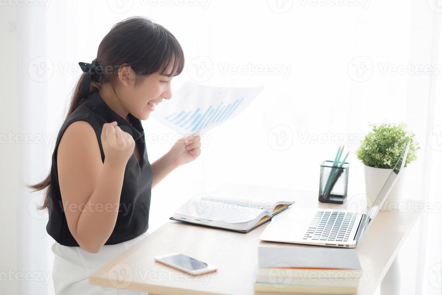 Beautiful young asian woman working laptop computer at office, businesswoman looking graph diagram analysis statistic data with excited and success, girl using notebook, business concept. photo