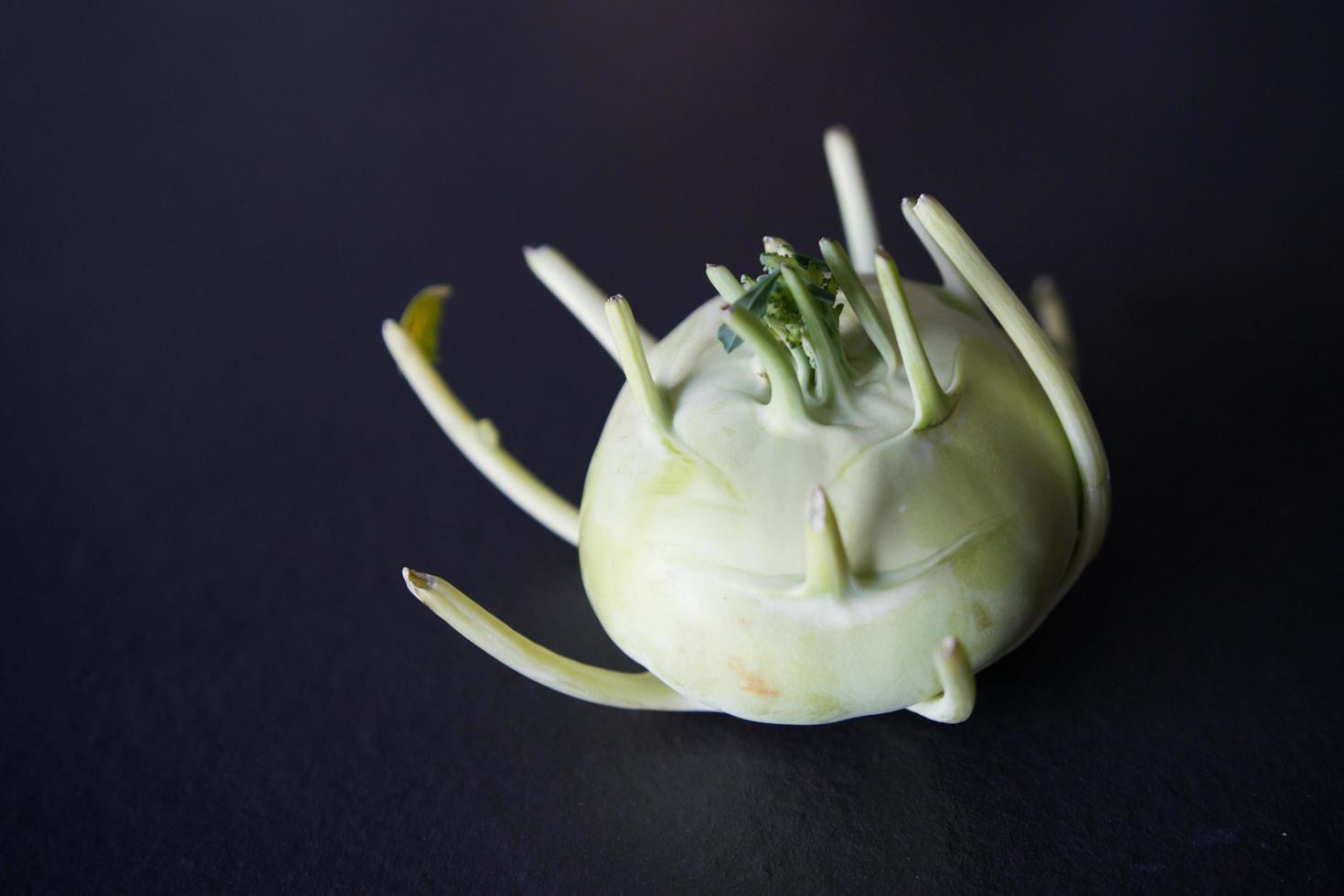 German turnip or kohlrabi, a strange vegetable with black background photo