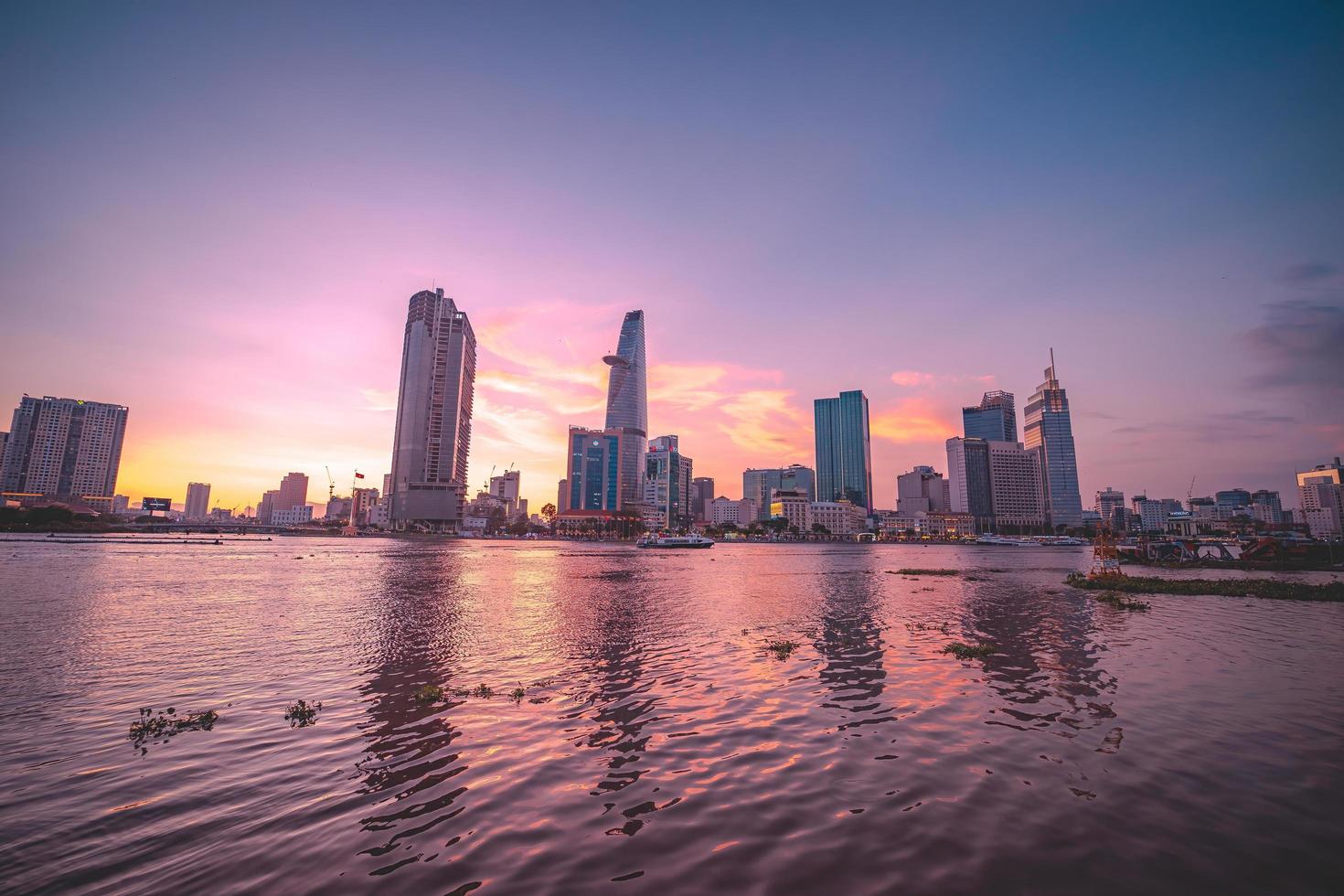 ho chi minh, vietnam - 13 de febrero de 2022 vista del edificio de la torre financiera bitexco, edificios, carreteras, puente thu thiem y río saigon en la ciudad de ho chi minh al atardecer. imagen panorámica de alta calidad. foto