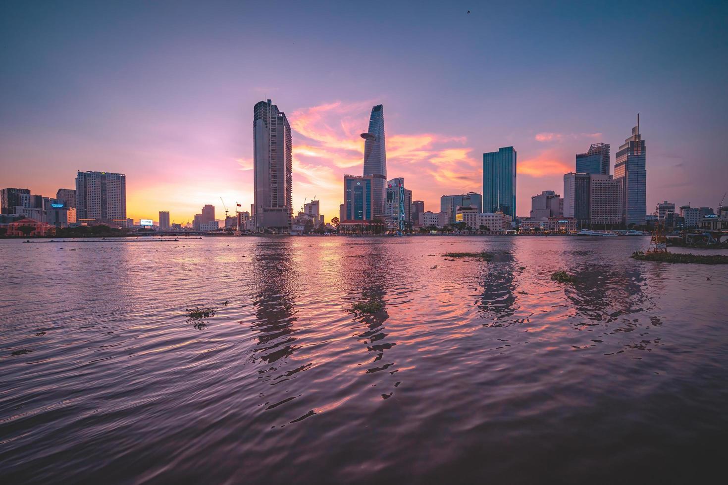 ho chi minh, vietnam - 13 de febrero de 2022 vista del edificio de la torre financiera bitexco, edificios, carreteras, puente thu thiem y río saigon en la ciudad de ho chi minh al atardecer. imagen panorámica de alta calidad. foto