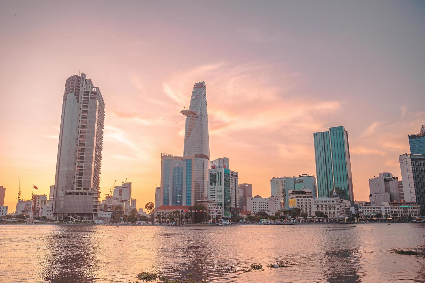 ho chi minh, vietnam - 13 de febrero de 2022 vista del edificio de la torre financiera bitexco, edificios, carreteras, puente thu thiem y río saigon en la ciudad de ho chi minh al atardecer. imagen panorámica de alta calidad. foto