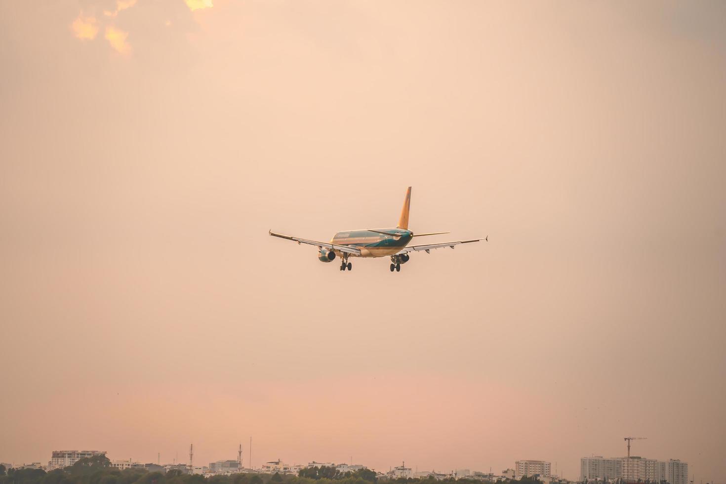 ciudad de ho chi minh, vietnam - 12 de febrero de 2022, un avión vuela sobre áreas urbanas preparando el aterrizaje en el aeropuerto internacional de tan son nhat y despega en el aeropuerto de tsn foto