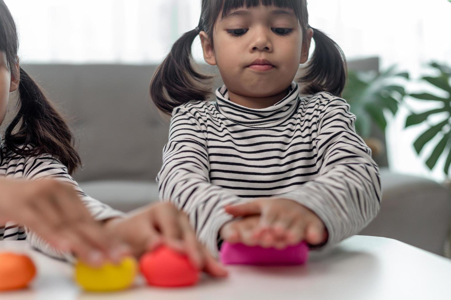 los niños asiáticos juegan con formas de moldeo de arcilla, aprendiendo a través del juego foto