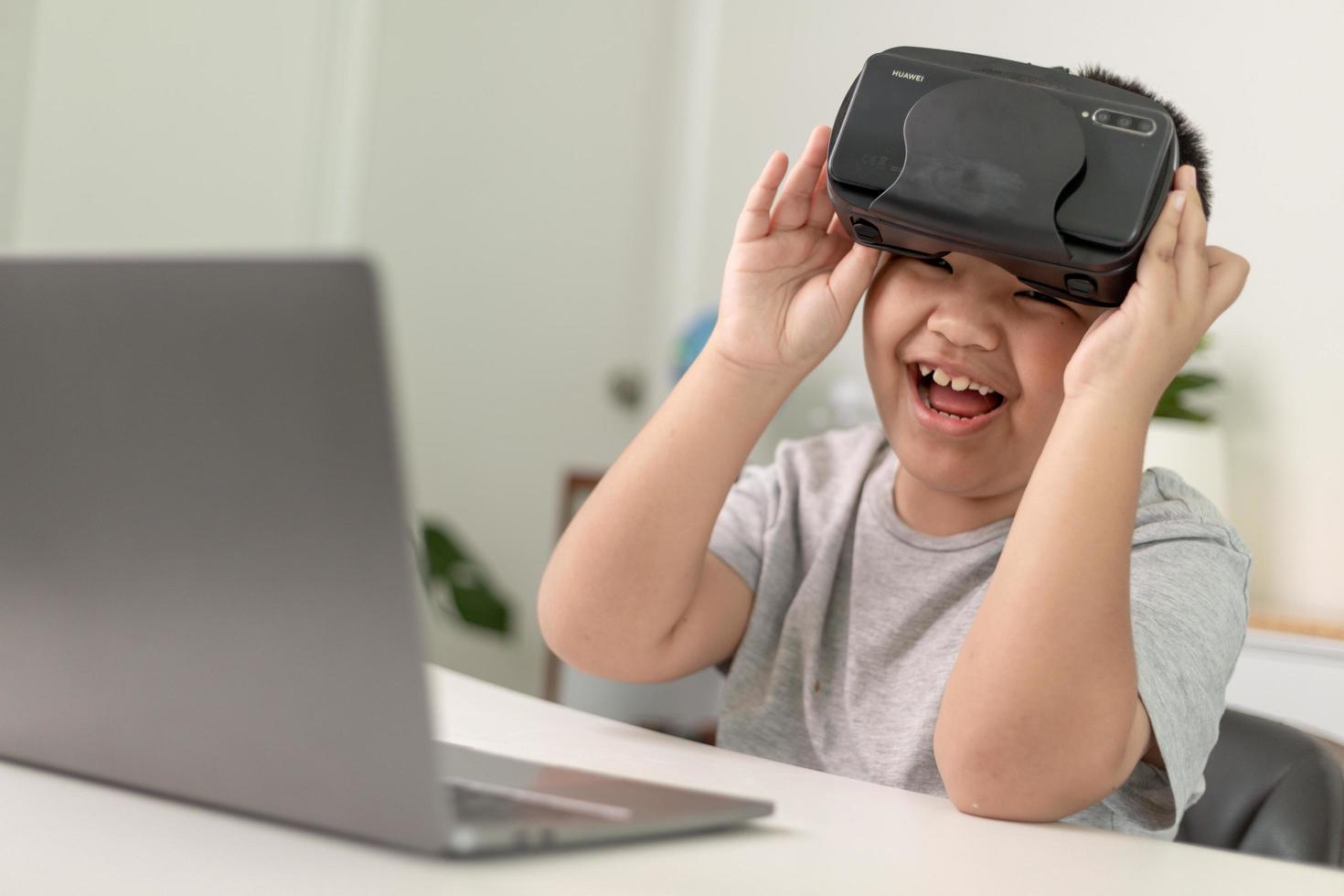 Asian Little boy with VR glasses studying sciences at home,curious student wears a virtual reality headset to study science home online study futuristic lifestyle learning photo