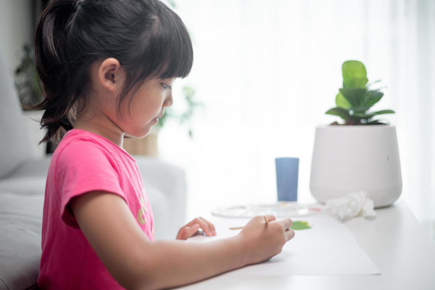 Girl Painting Picture On Table At Home photo