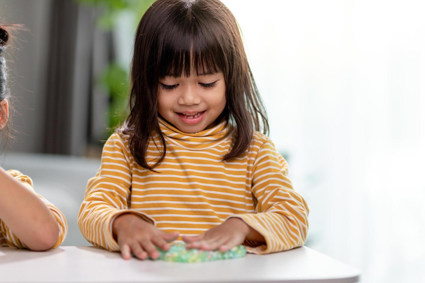 Kid play with handgum. Slime in children hands. photo