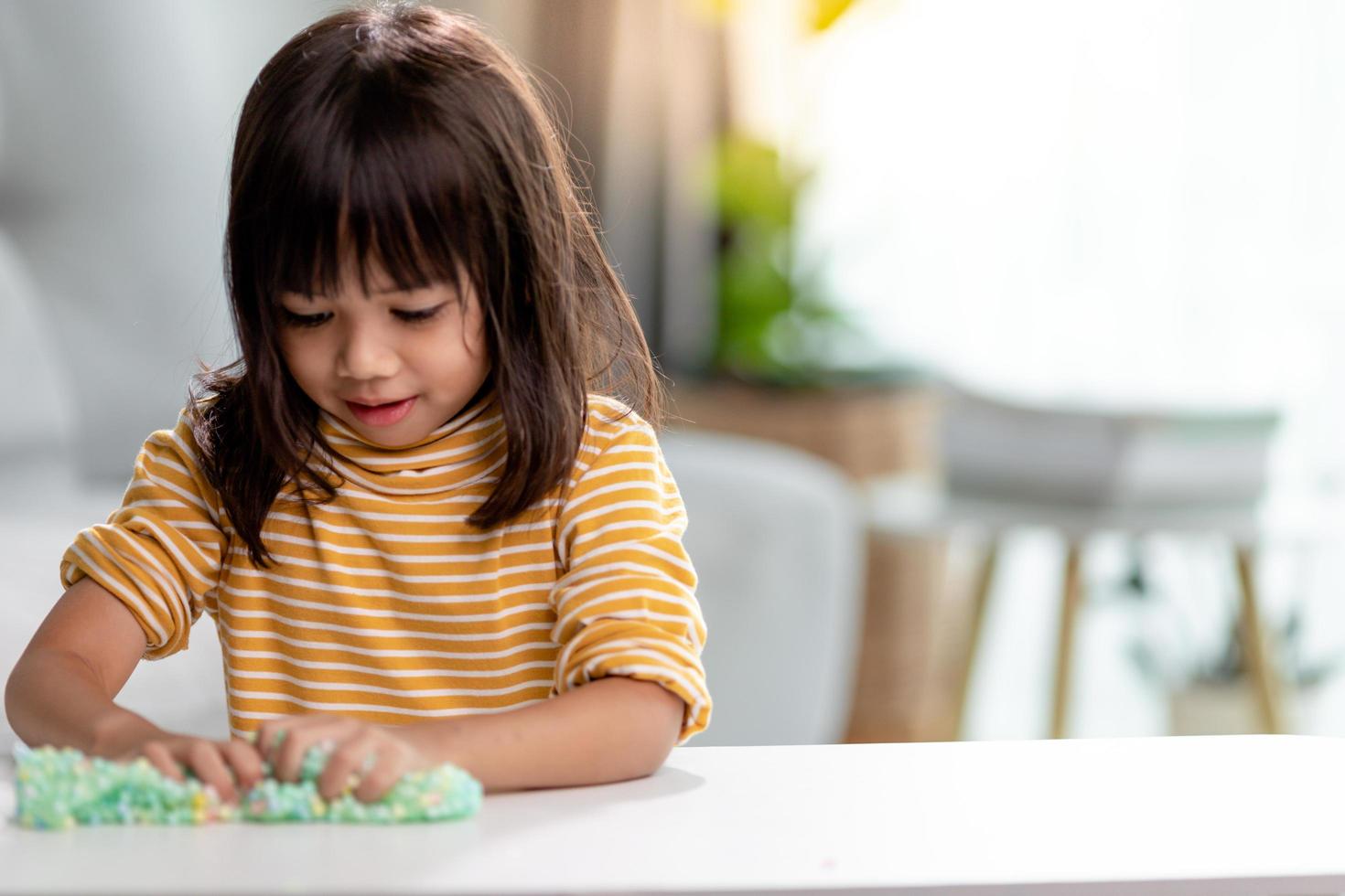 Kid play with handgum. Slime in children hands. photo