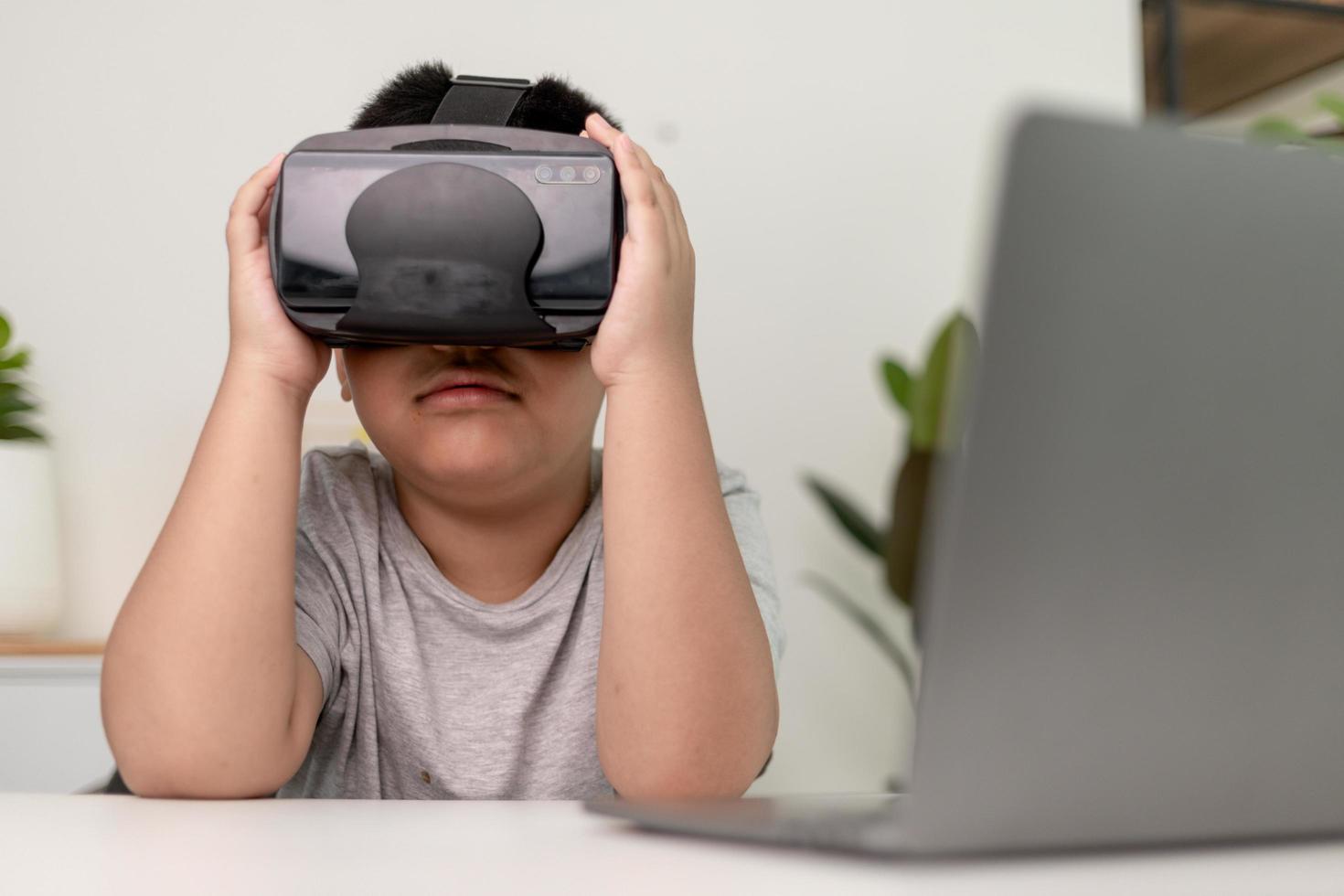 Asian Little boy with VR glasses studying sciences at home,curious student wears a virtual reality headset to study science home online study futuristic lifestyle learning photo