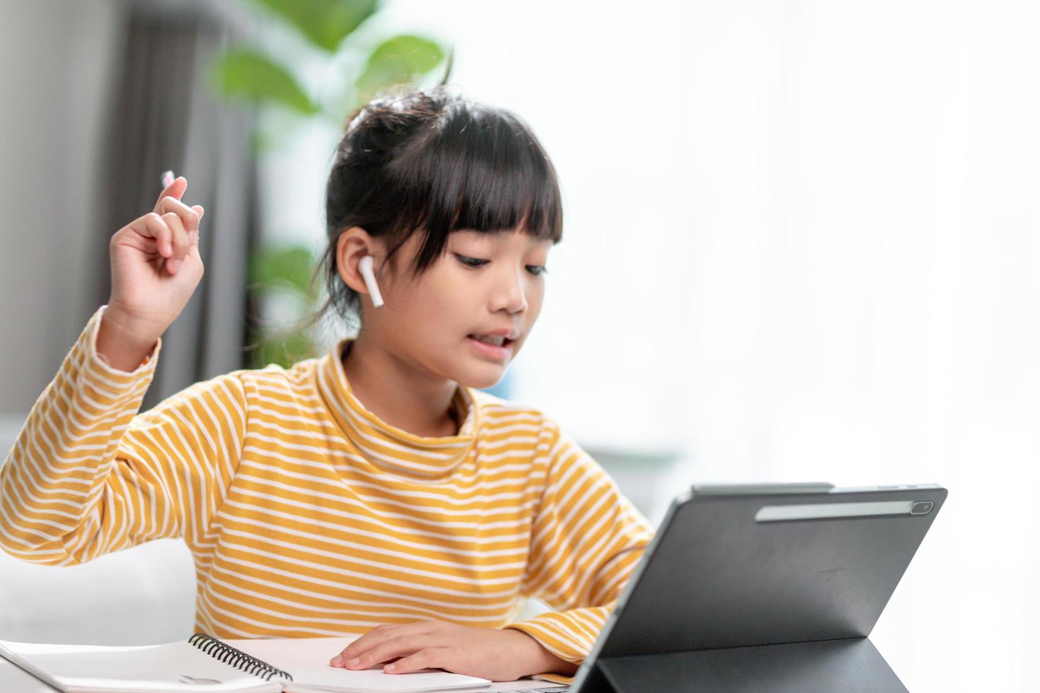 Kid self isolation using tablet for his homework,Child doing using digital tablet searching information on internet during covid 19 lock down,Home schooling,Social Distance,E-learning online education photo