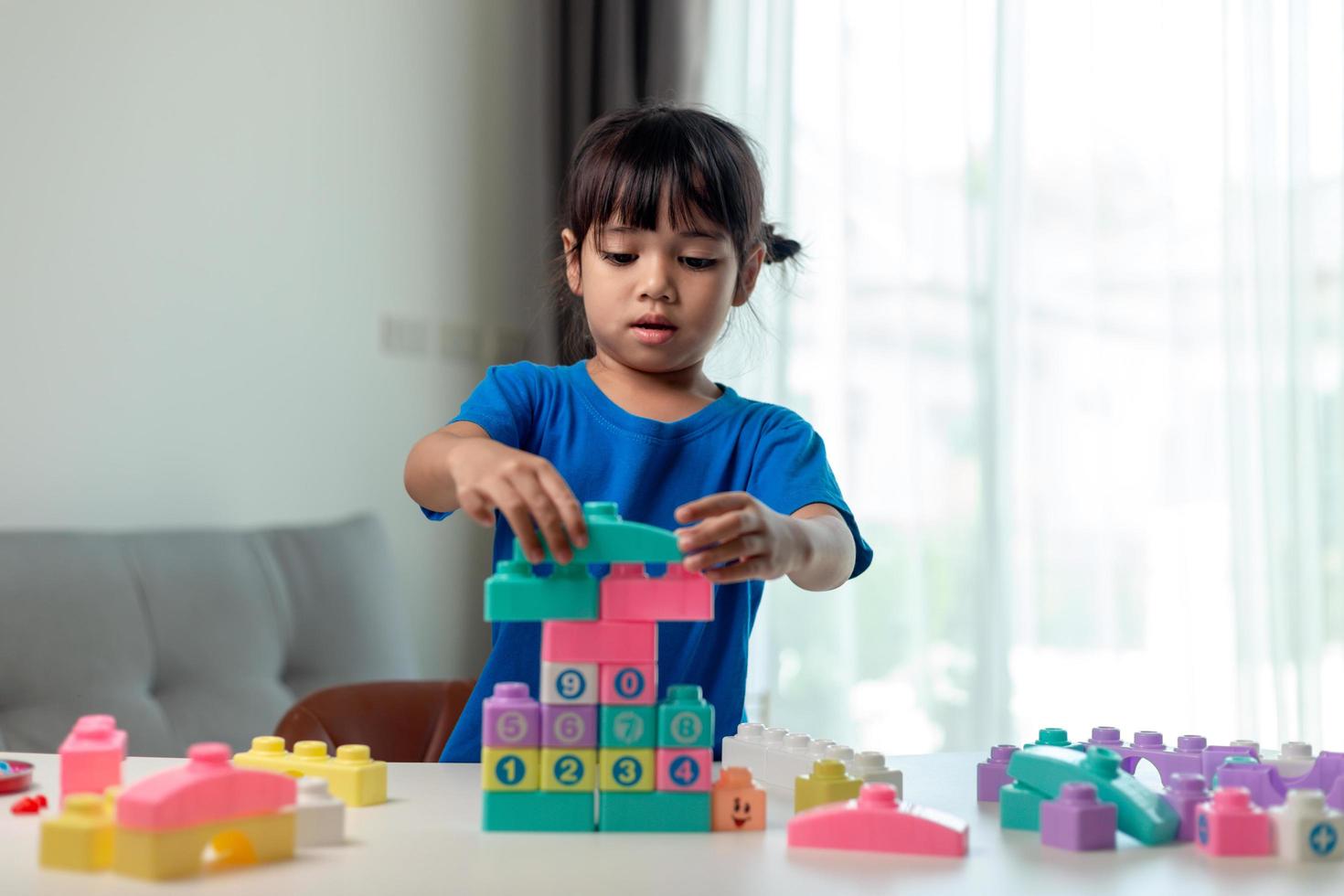 Little child girl playing colorful blocks photo