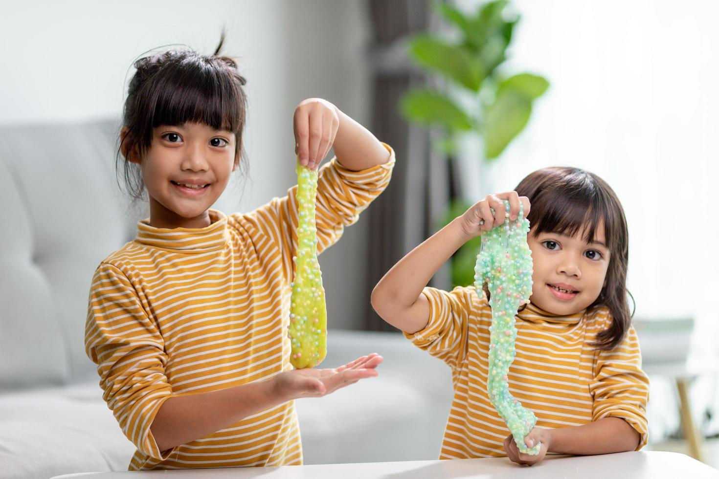 Kid play with handgum. Slime in children hands. photo