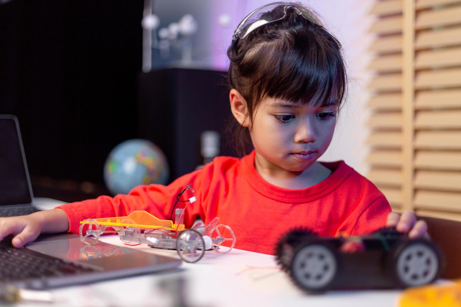 Asia students learn at home in coding robot cars and electronic board cables in STEM, STEAM, mathematics engineering science technology computer code in robotics for kids concept. photo