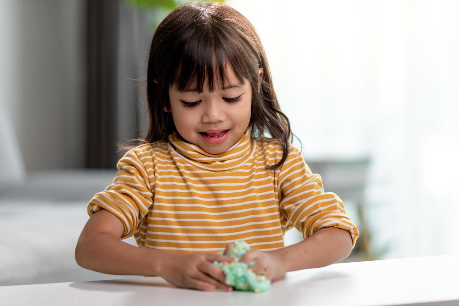 Kid play with handgum. Slime in children hands. photo