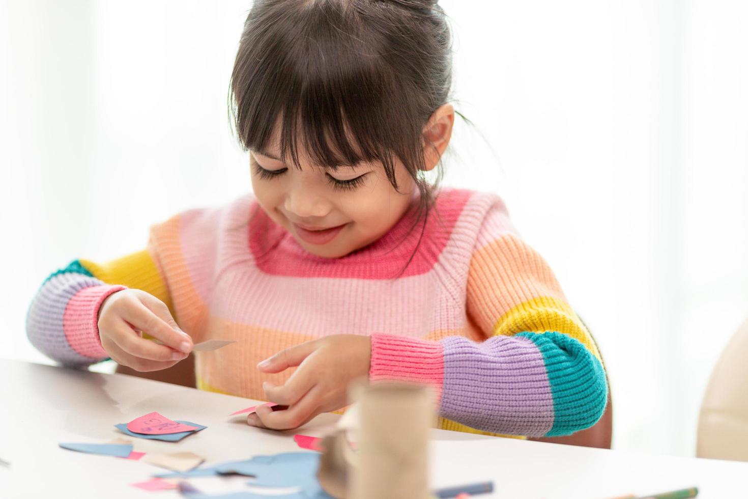Little cute girl with painted tissue core. Art makes children learn and create. photo