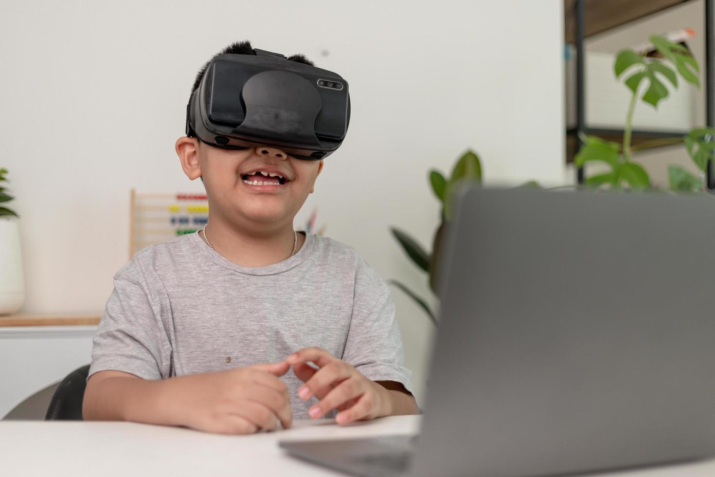 Asian Little boy with VR glasses studying sciences at home,curious student wears a virtual reality headset to study science home online study futuristic lifestyle learning photo