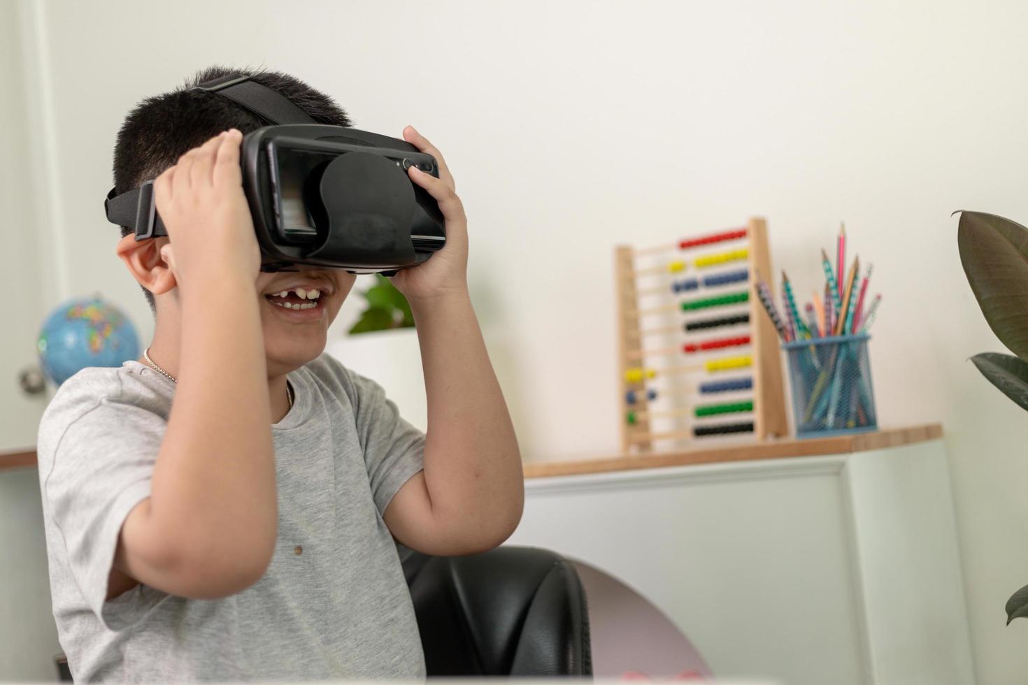 Asian Little boy with VR glasses studying sciences at home,curious student wears a virtual reality headset to study science home online study futuristic lifestyle learning photo