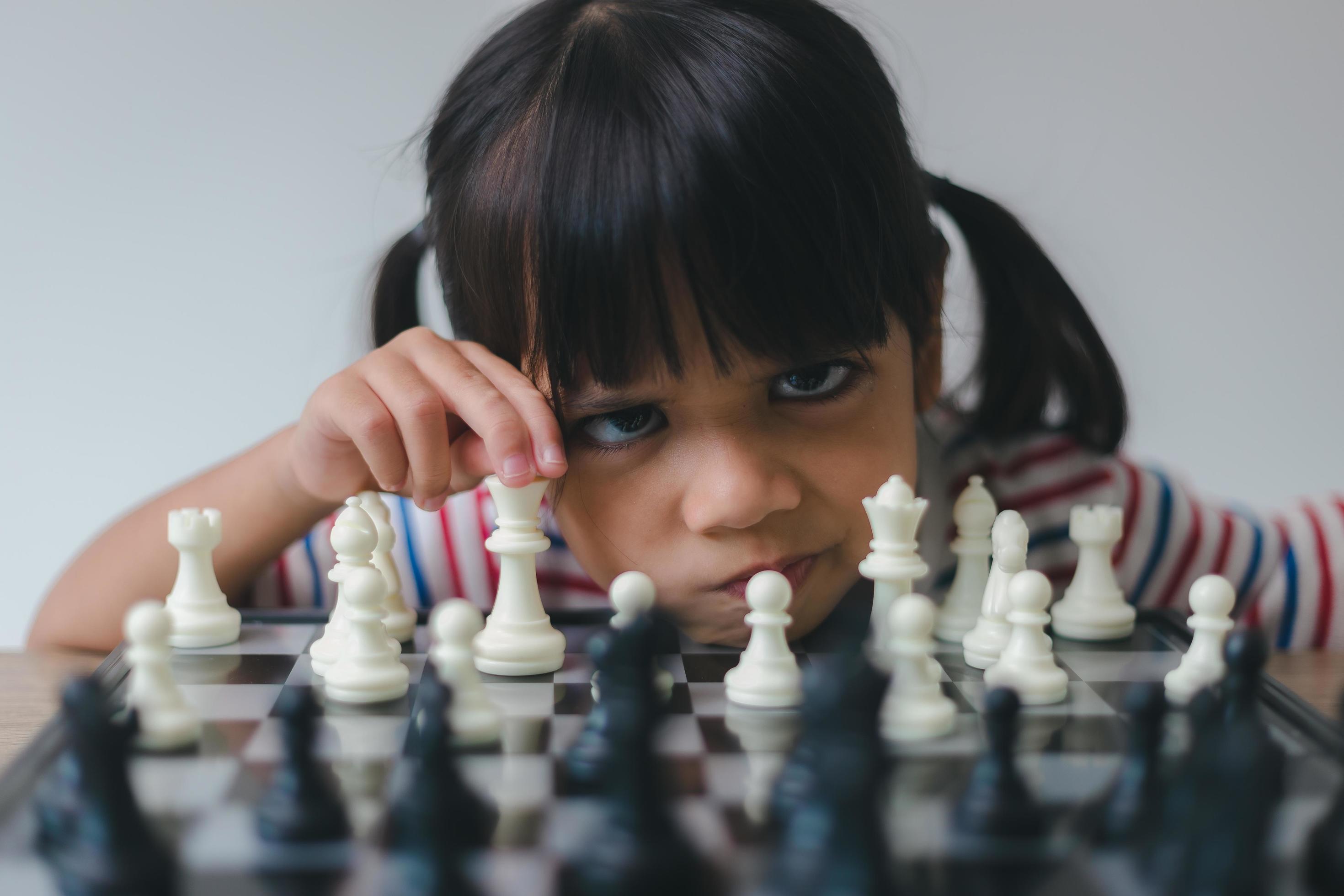 Asian little girl playing chess at home.a game of chess 10076348 Stock