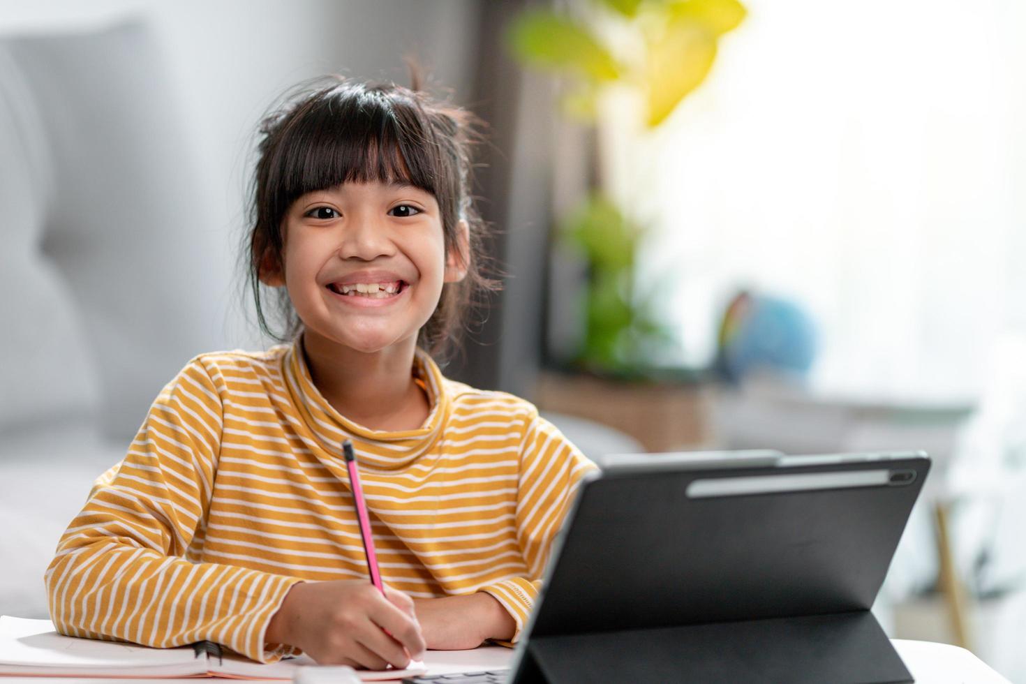 Kid self isolation using tablet for his homework,Child doing using digital tablet searching information on internet during covid 19 lock down,Home schooling,Social Distance,E-learning online education photo