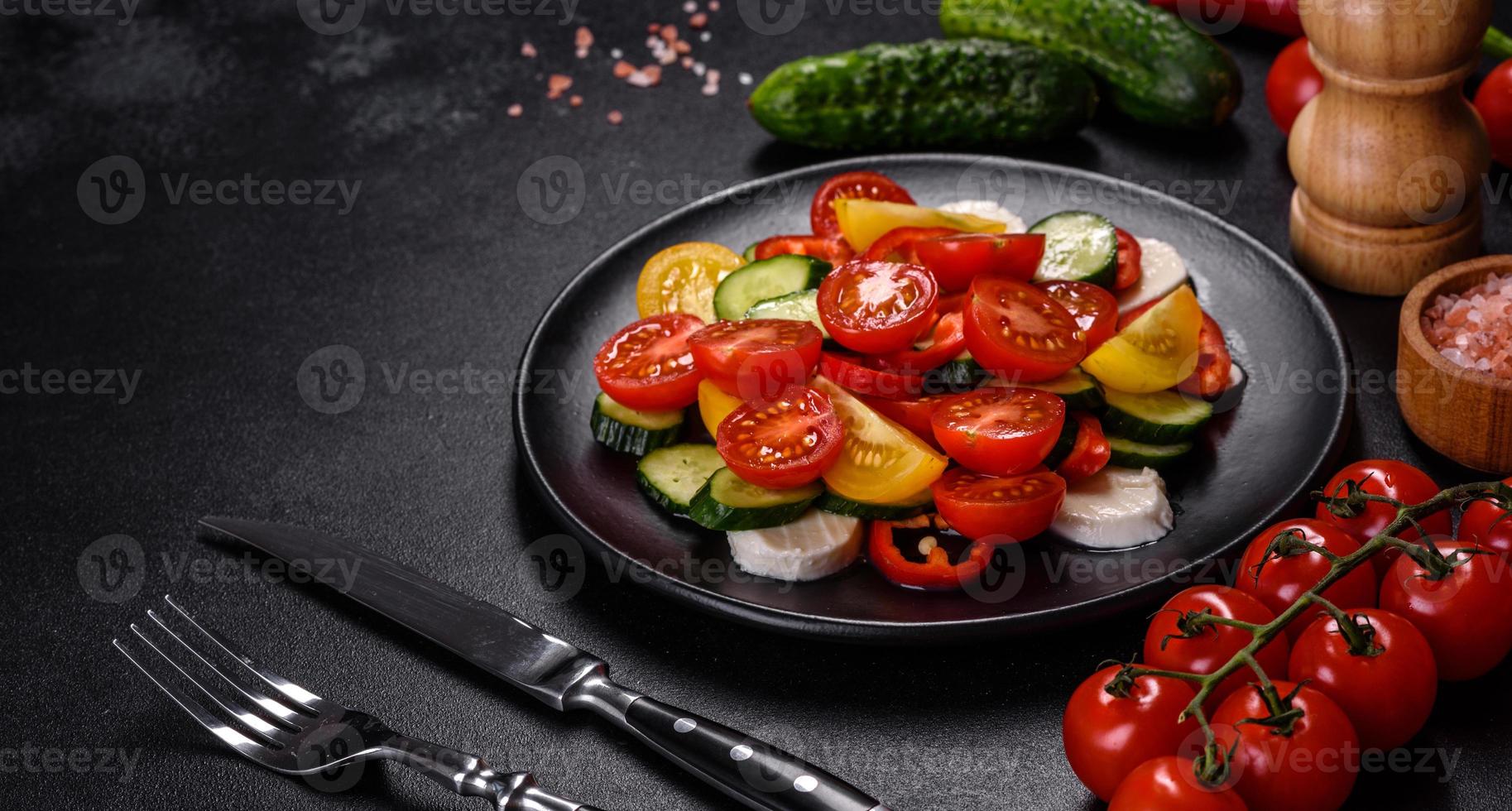 ensalada fresca y deliciosa con tomates cherry, pepinos, pimientos dulces, queso y aceite de oliva foto