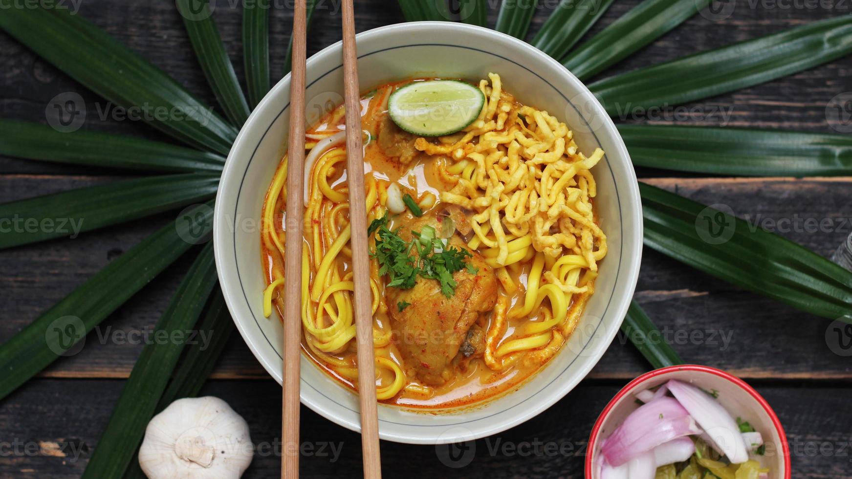 Khao Soi Recipe,Khao Soi,Khao Soi Kai, Thai Noodles Khao Soi, Chicken Curry with seasoning served on wooden table photo