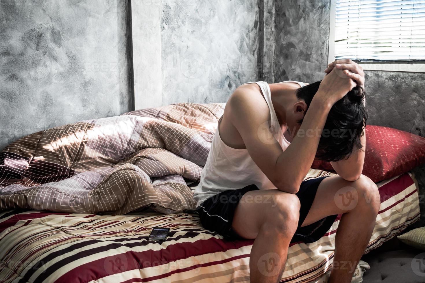 Depressed young man sitting in his bedroom photo