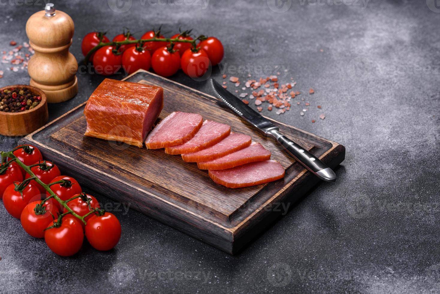 Delicious smoked meat cut with slices on a wooden cutting board