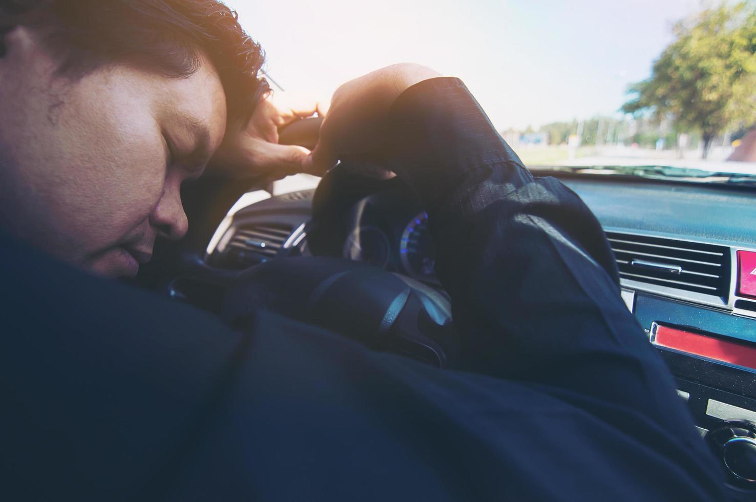 Man sleep in car while driving on the road - people tried from long drive and traffic concept photo