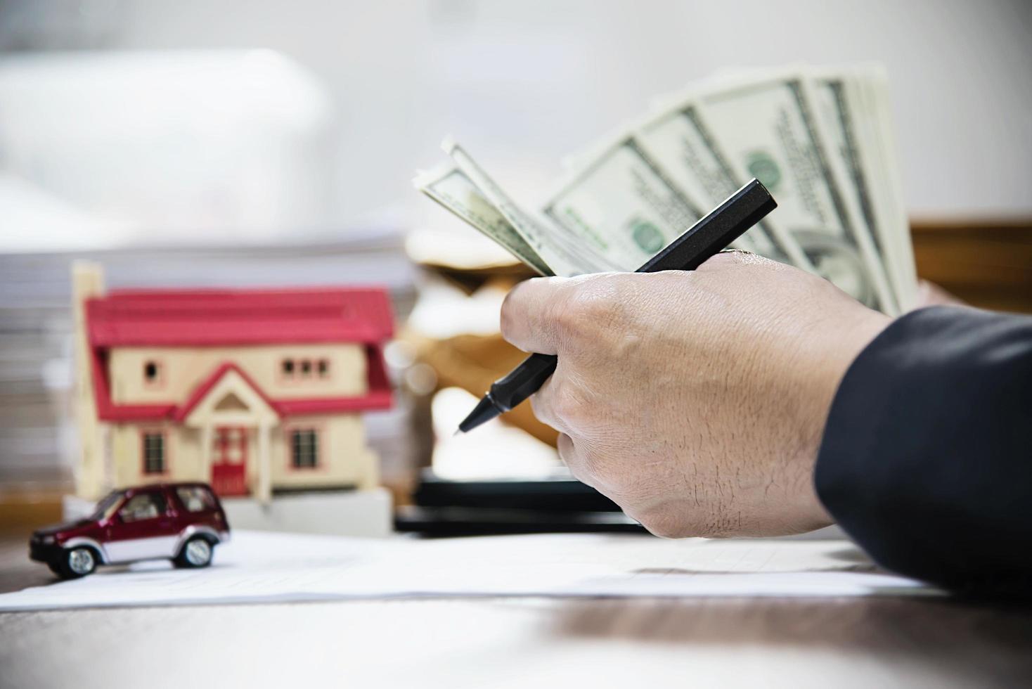 hombre de negocios contando dinero billete de dólar calculando préstamos para el hogar y el automóvil - concepto de bienes raíces de estilo de vida de seguro financiero personal foto