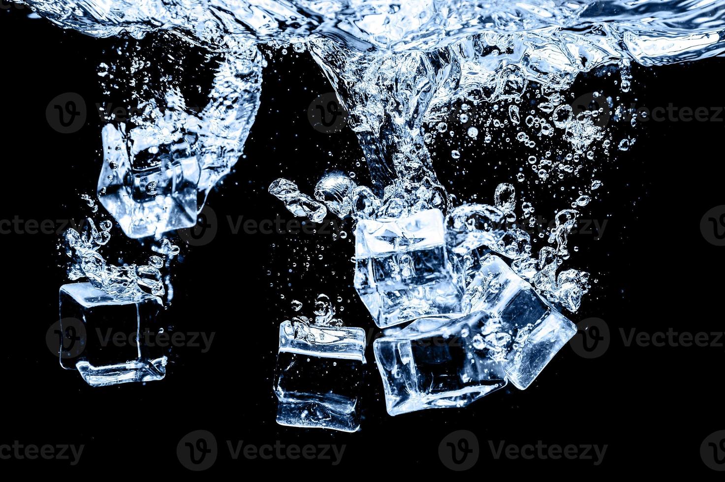 cubos de hielo en agua sobre fondo oscuro de estudio. el concepto de frescura con frialdad de cubitos de hielo. foto