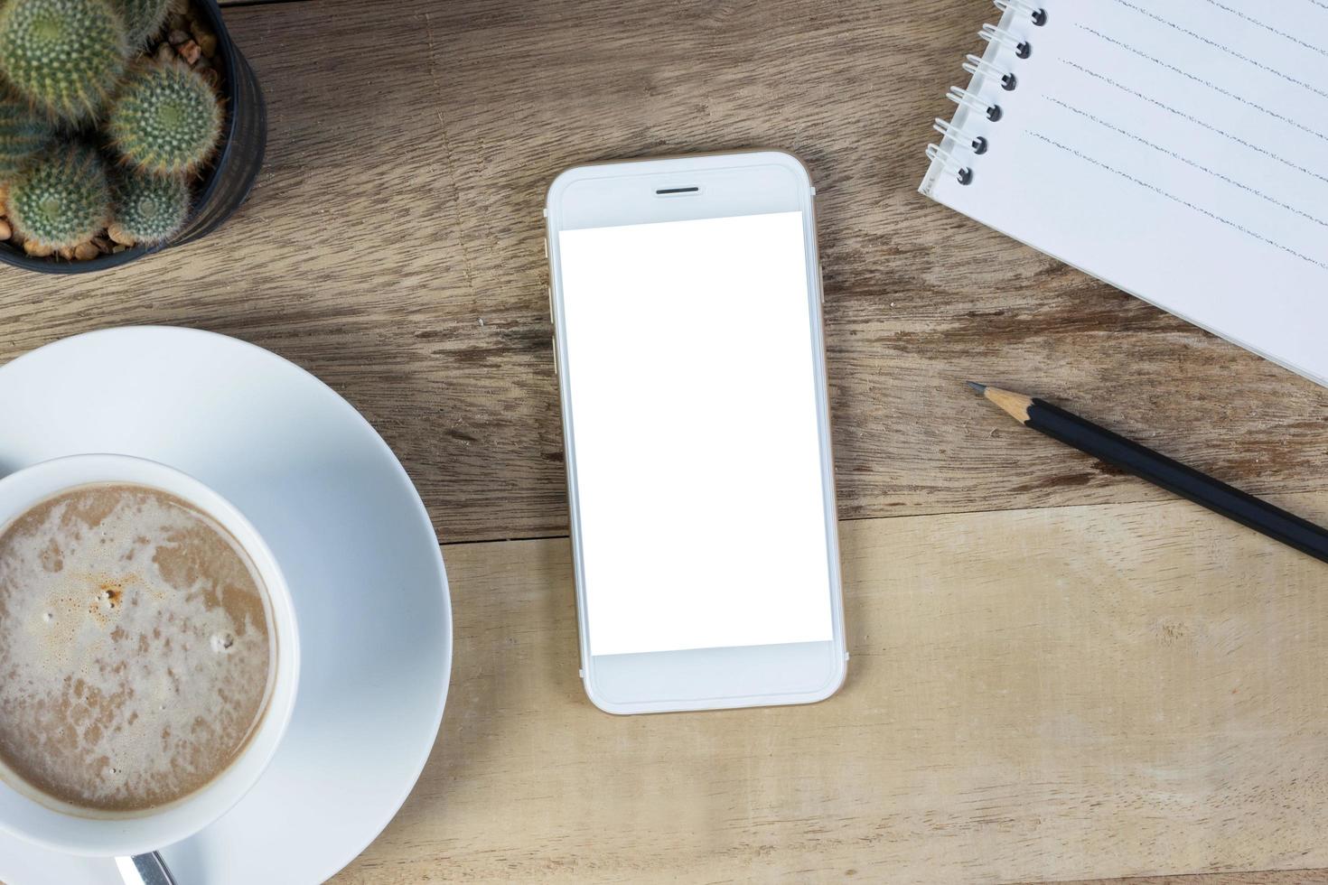 Top view of blank screen smart phone on on wood desk work. photo