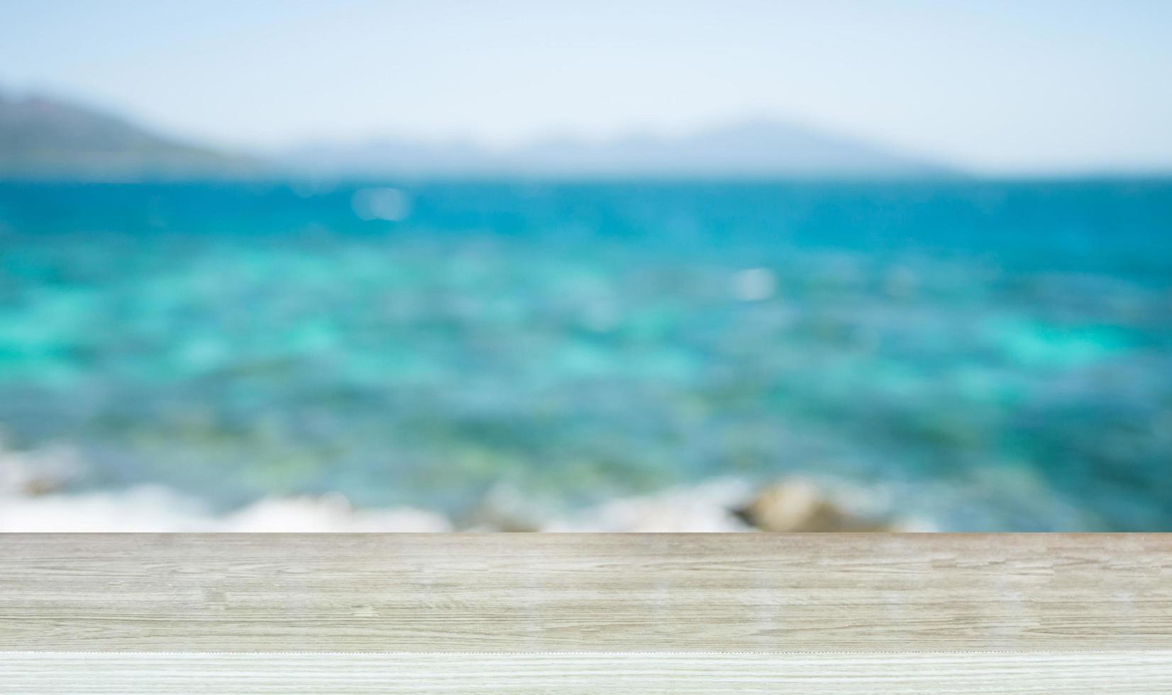 Empty top of wooden table and view of tropical beach photo