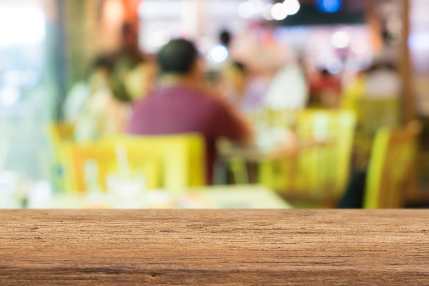 Wood table top with blurred people in cafe as background  for display products photo