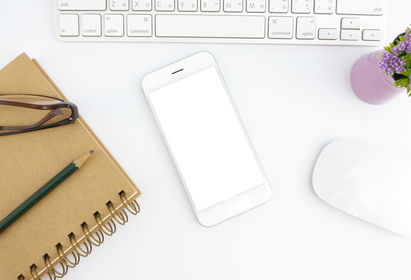 Top view of blank screen smart phone on white table work photo