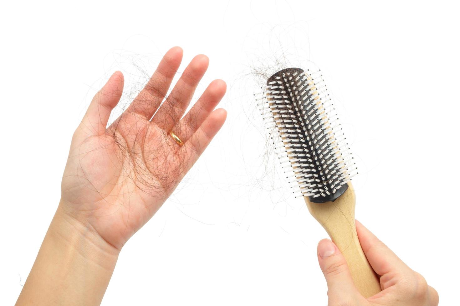 Hair loss in woman hands and bruch, on white background photo