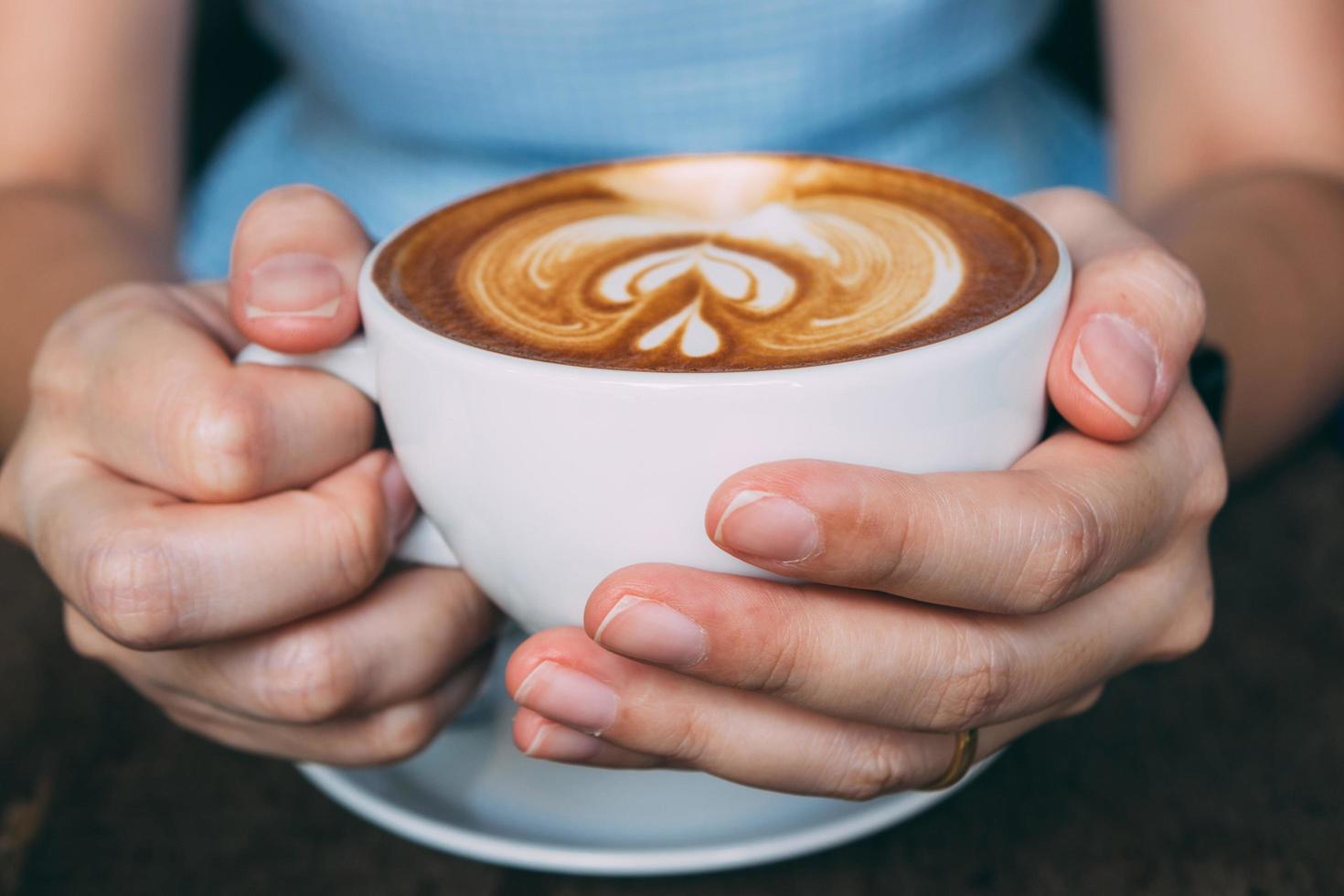 Woman hands holding Latte art with vintage tone photo