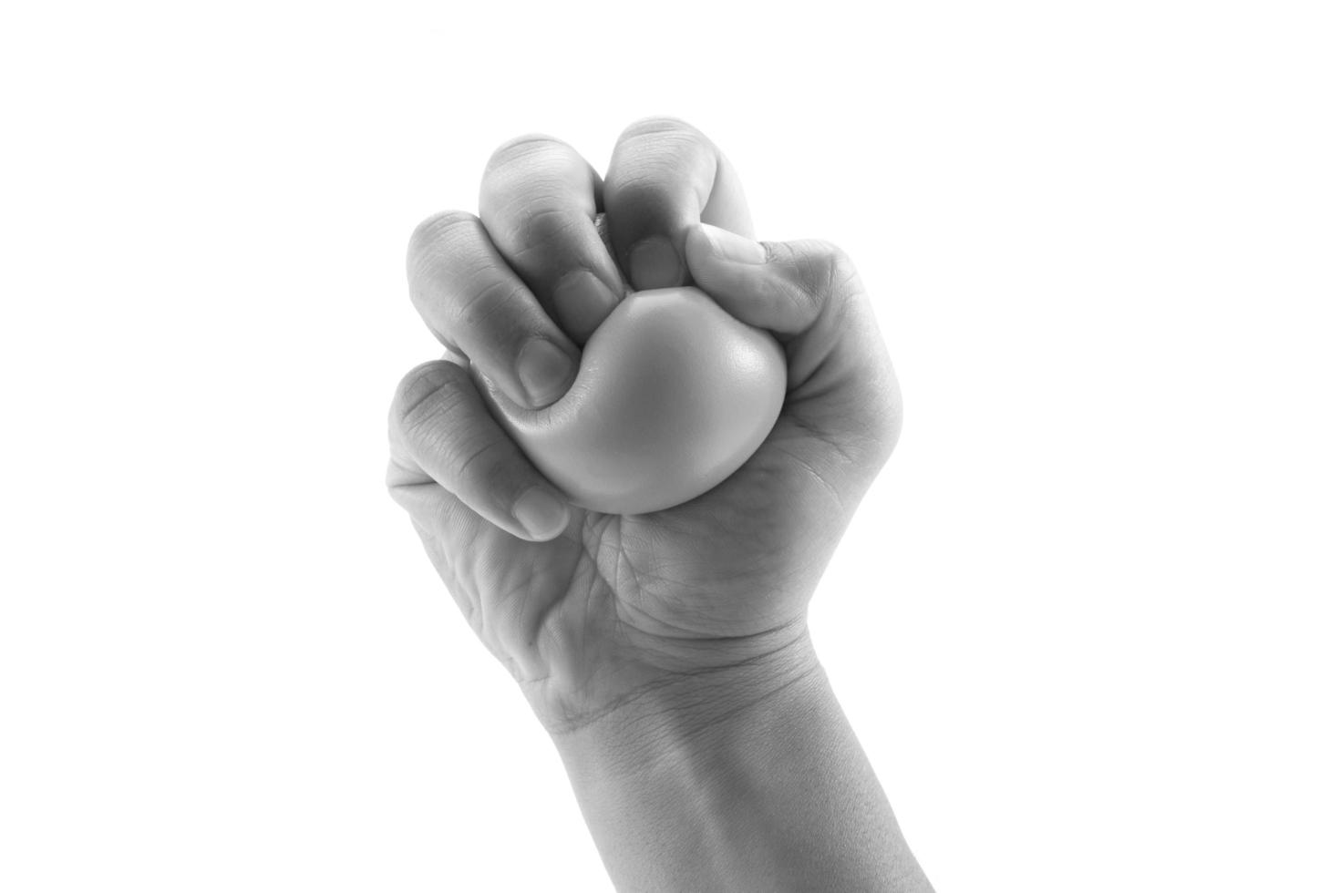 Hand squeezing a stress ball  on white background photo