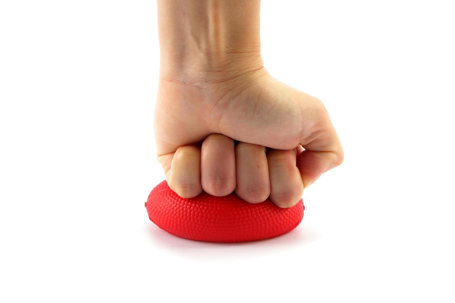 Woman hand squeezing a stress ball  on white background photo