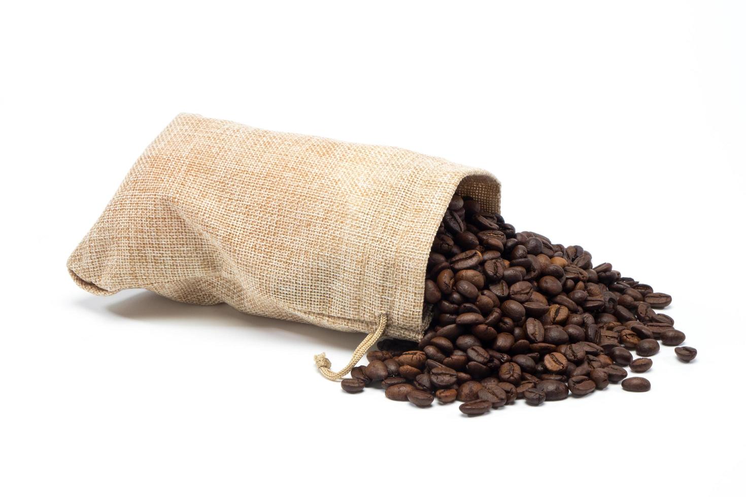 granos de café con bolsa de arpillera sobre fondo blanco foto