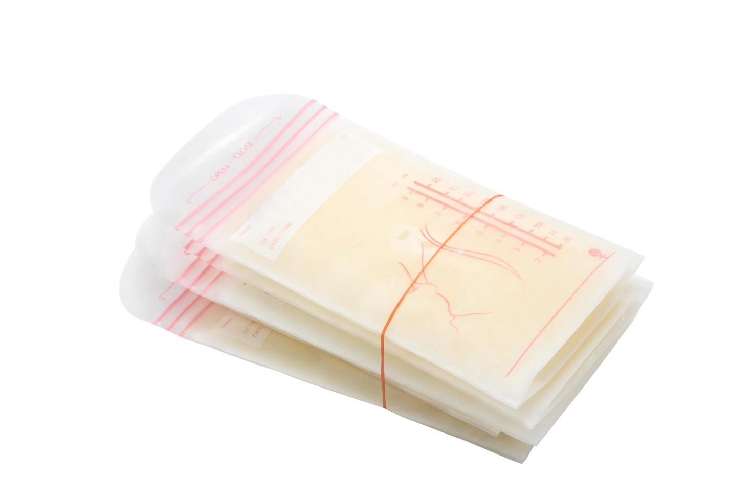 Breast milk frozen in storage bags for baby on white photo