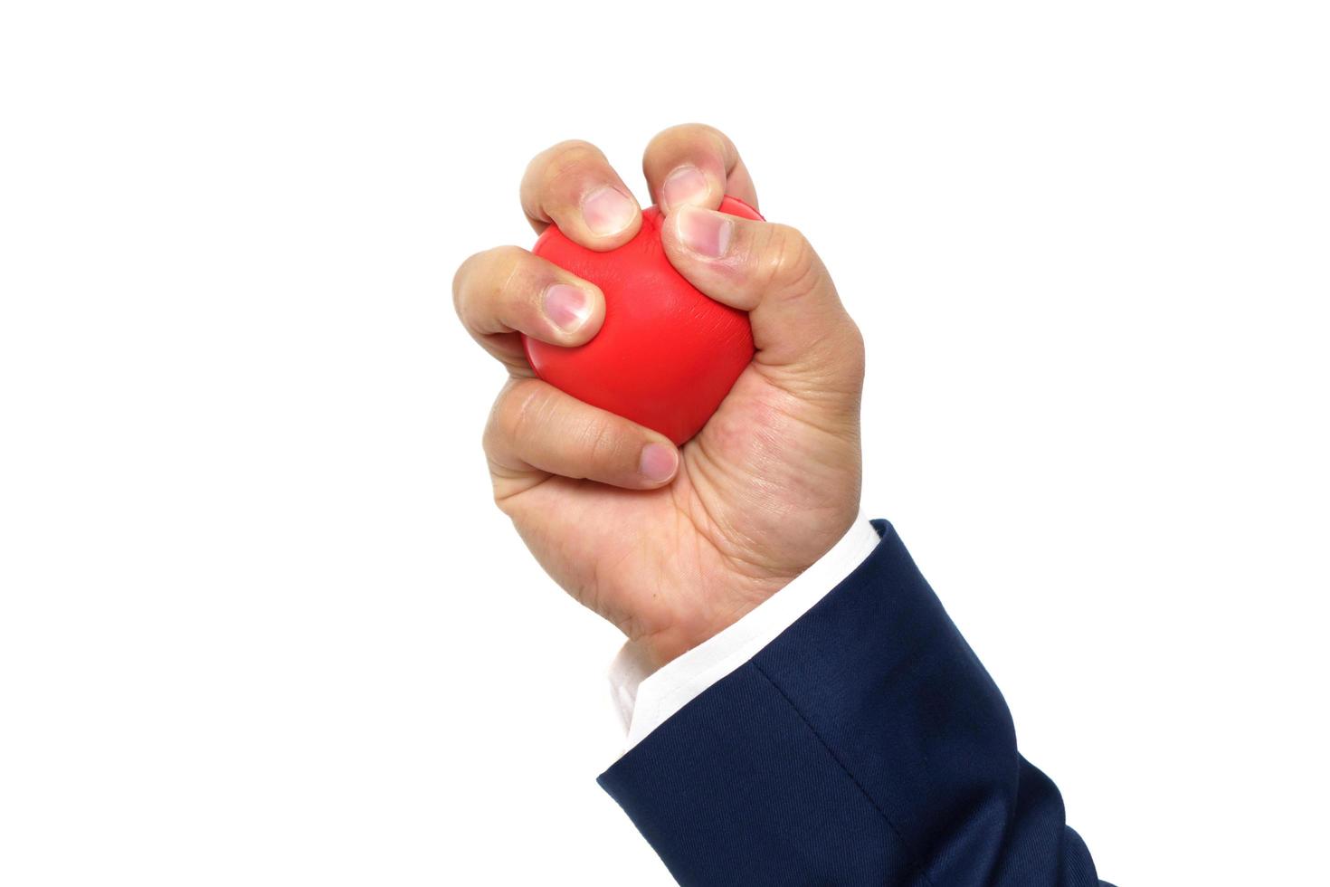 A man hand squeezing a stress ball on white background photo