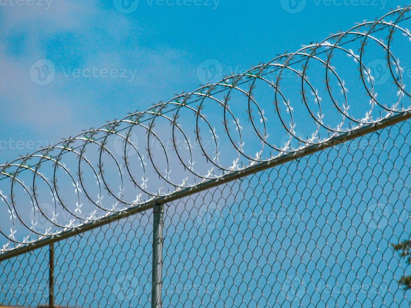 Razorwire fence atop a chain link fence photo