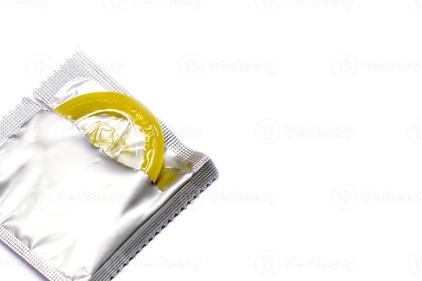 Condom in package is opened on white background. photo